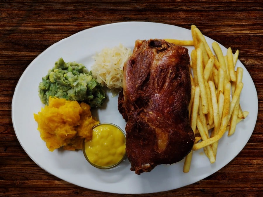Traditional Pub Fare of eisbein served with home fermented sauerkraut, a portion of hot seasoned chips and traditional roasted vegetables